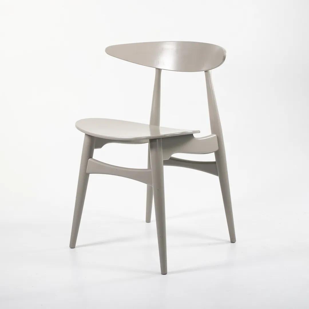 Listed for sale is a CH33T Chair designed by Hans Wegner and produced by Carl Hansen & Son in Denmark. The chair is made with a solid beech frame and painted Silver Grey (we believe this to be the correct color, though it is not guaranteed). The