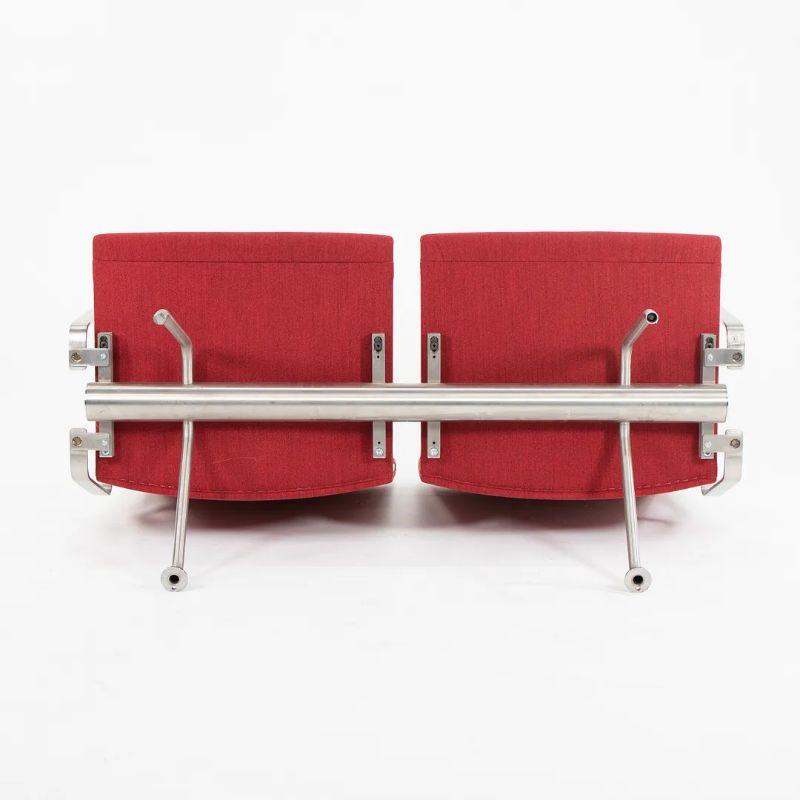Listed for sale is a two-seater Kastrup sofa model CH402 with arms, designed by Hans Wegner , produced by Carl Hansen & Son in Denmark. The sofa is made with a stainless steel frame and red fabric. It was produced circa 2020 and is guaranteed as