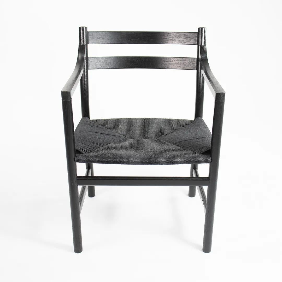 Listed for sale is a CH46 Dining Chair designed by Hans Wegner, produced by Carl Hansen & Son in Denmark. The chair is made with a black solid oak frame and black paper cord seat. This chair dates to circa 2020 and is guaranteed as