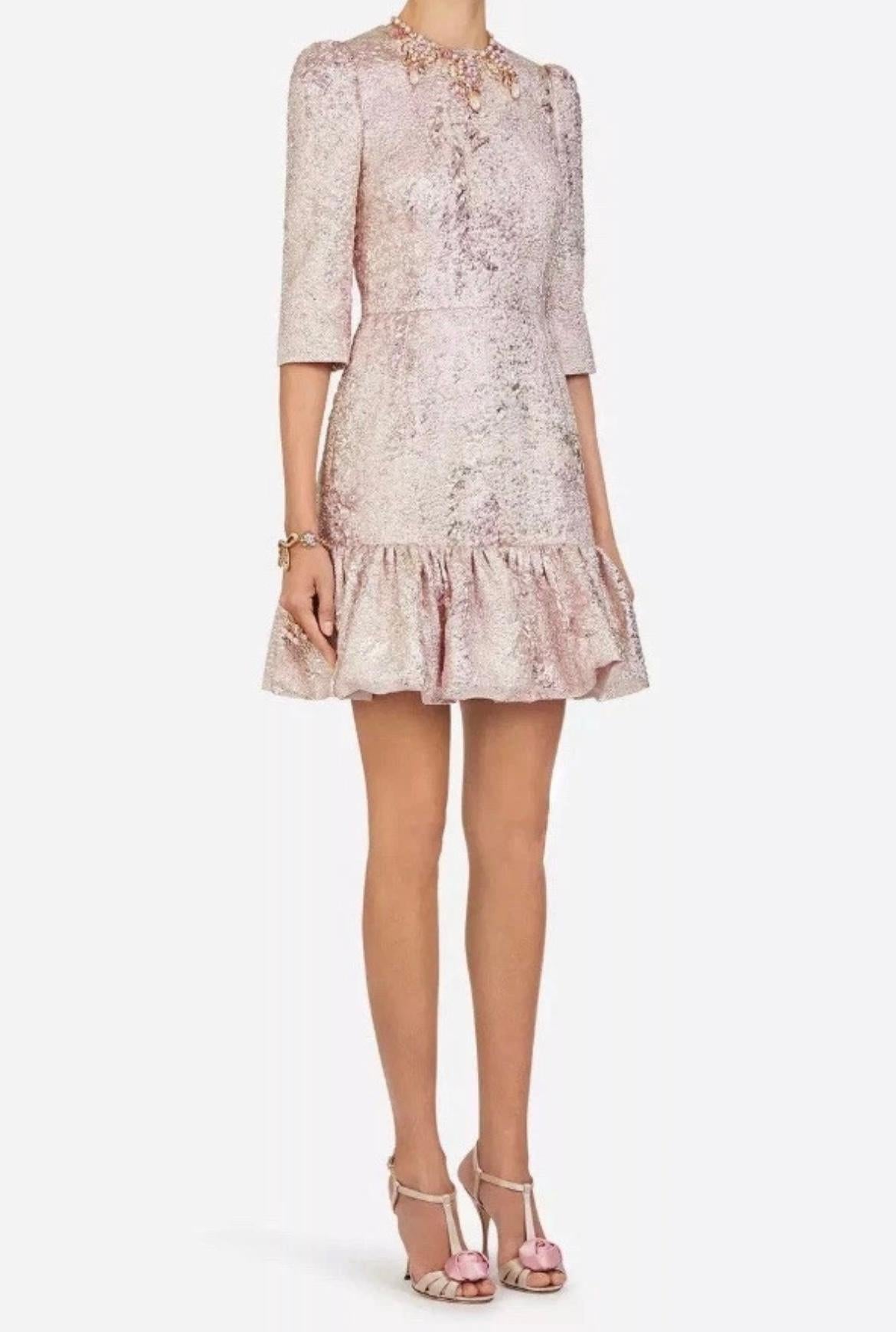 Cette robe rose métallisée à haute teneur en oxygène a été conçue par Dolce & Gabbana pour sa collection printemps/été 2020. Taillée dans la plus belle des étoffes, elle est coupée dans un tissu jacquard lamé chatoyant rose pâle qui brille d'un