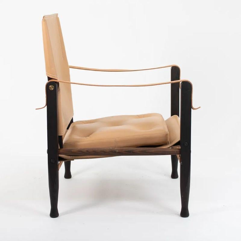 This is a KK47000 Safari Lounge Chair designed by Kaare Klint and produced by Carl Hansen & Son in Denmark. The chair is made with a ebonized ash wood frame and Thor leather upholstery (the arms appear to be vegetable tanned and natural, whereas the