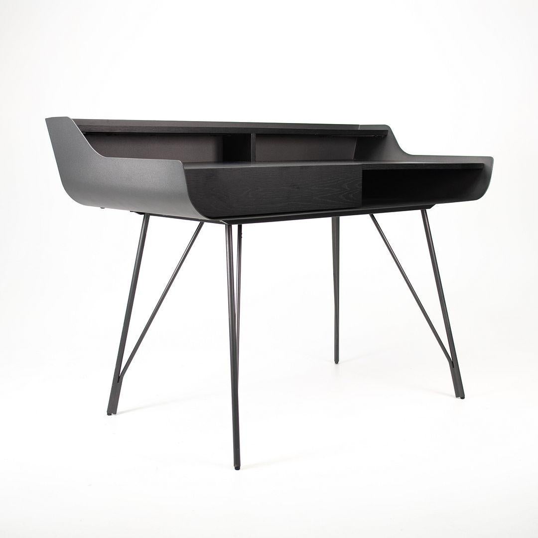 Questa è una scrivania Noori, originariamente progettata e prodotta da Living Designs. Questo particolare esemplare è stato prodotto in Canada nel 2020. La scrivania è caratterizzata da un piano rettangolare e lineare rifinito in nero onice,