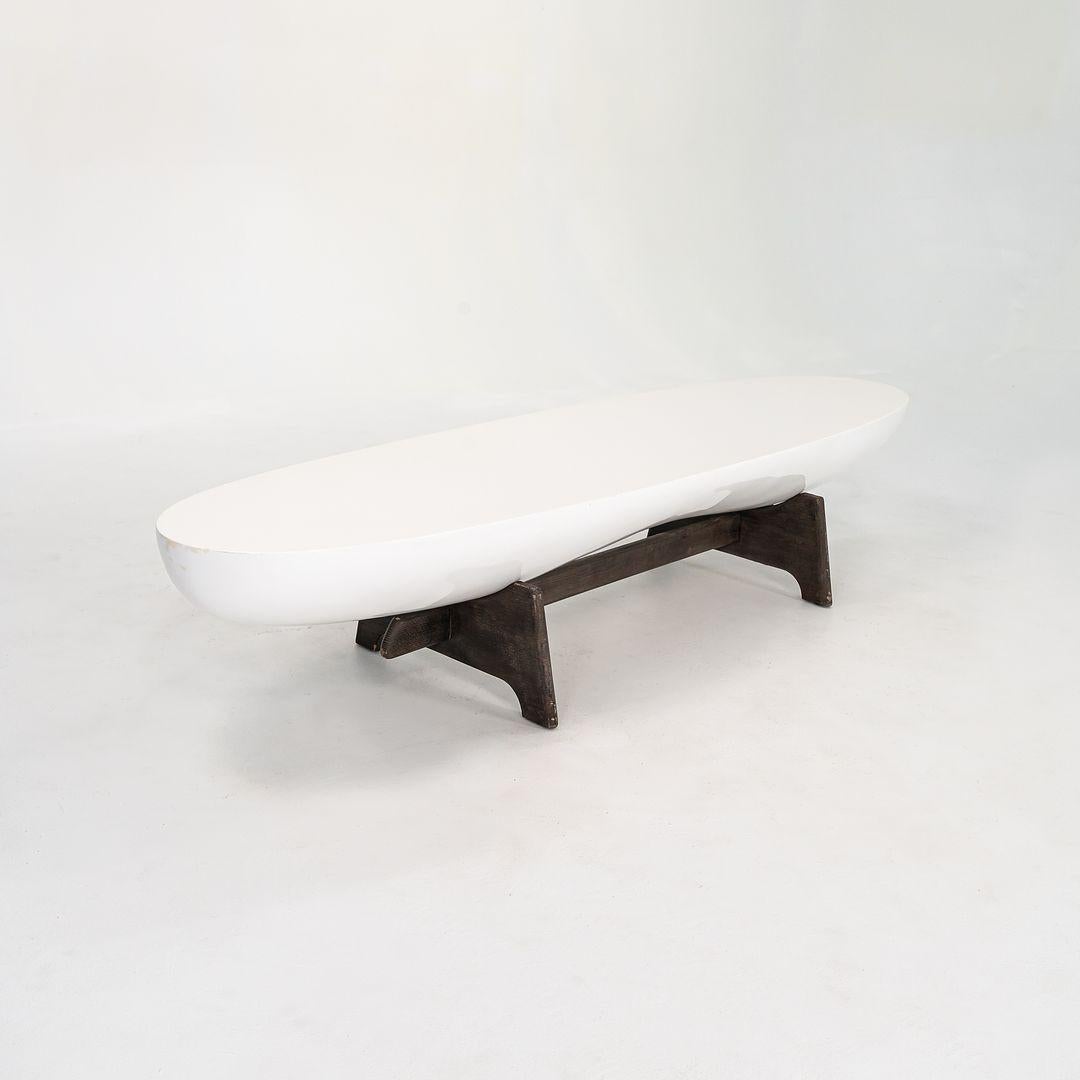 Esta es una mesa de centro Danica, diseñada por el artista afincado en Los Ángeles Thomas Bina. La pieza se fabricó en 2020 en EEUU. Esta mesa tiene una base de roble francés y el tablero es de fibra de vidrio lacada en blanco. El diseño es