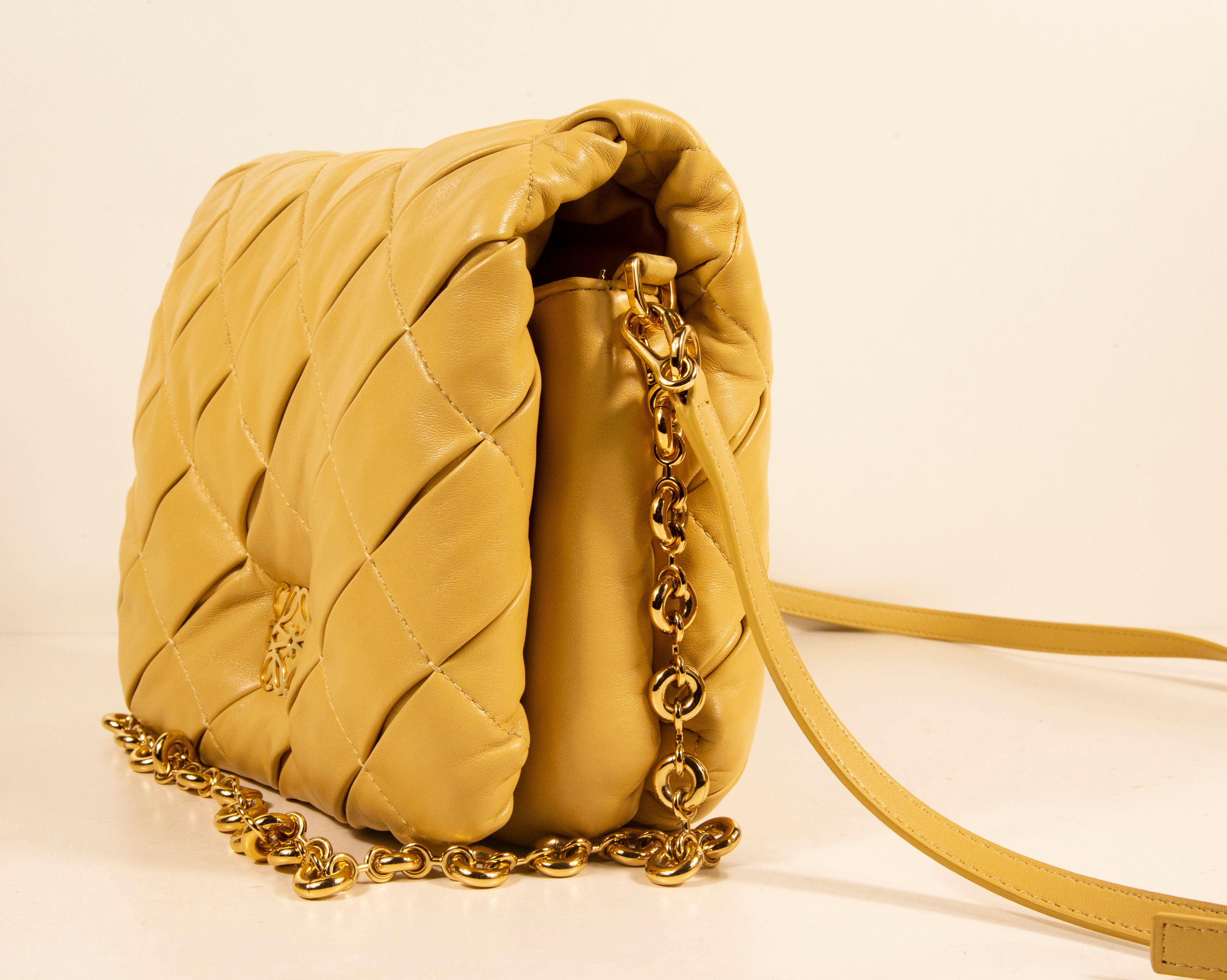 The Loewe's Goya Puffer bag made of camel-hued lamb leather and filled with goose feather. The hardware is gold toned. The interior features one major compartment and two side pockets of which one has a zipper. The bag can be worn as a shoulder bag