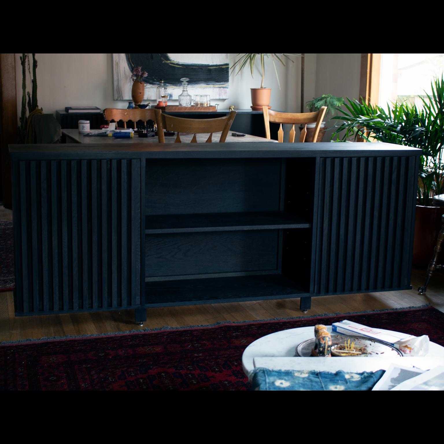 The Avicenna credenza is a beautifully understated piece with stunning Minimalist design that echoes midcentury aesthetic. 
The cabinet is constructed of entirely solid oak. The top is made from a thicker stock oak to add a weighted and permanent