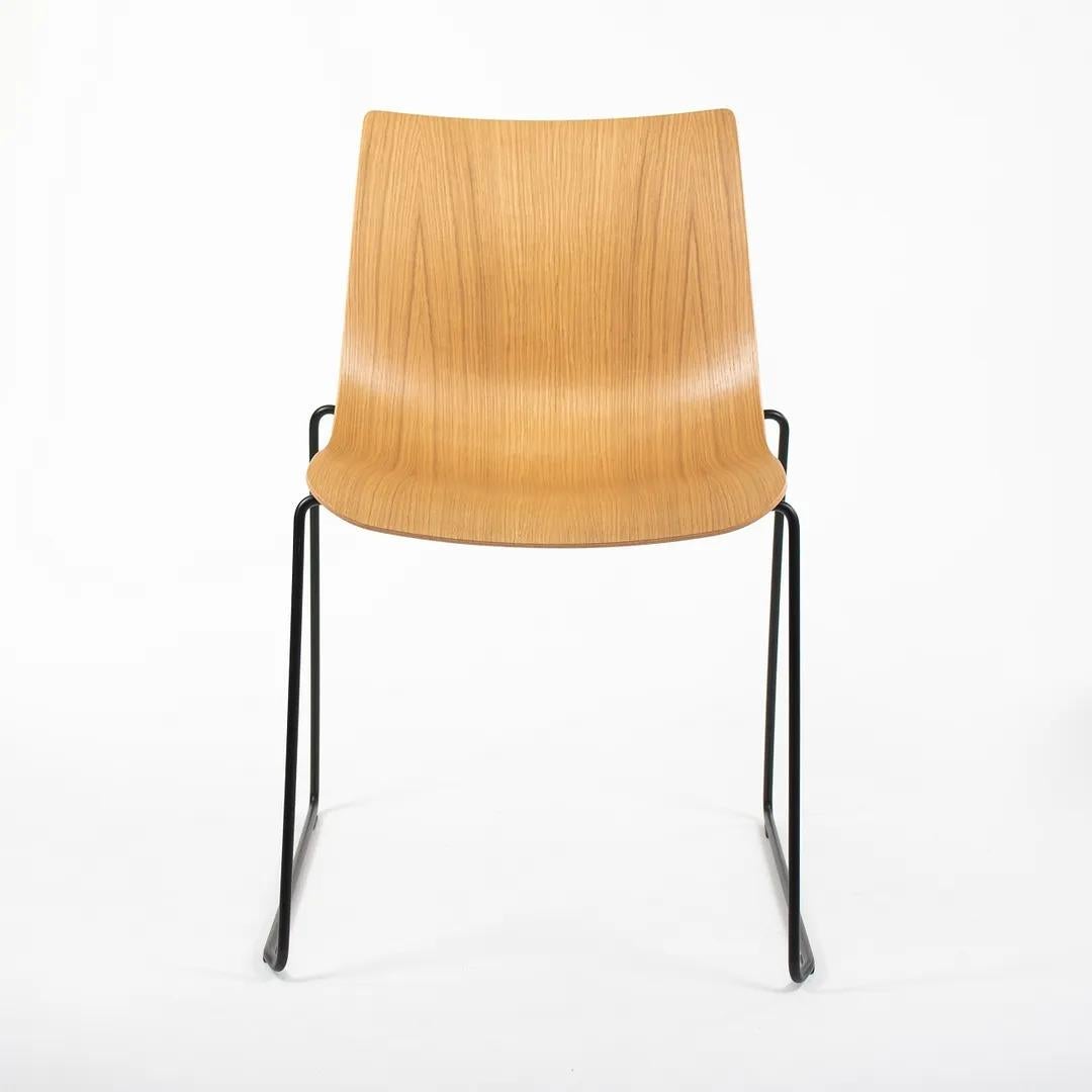This is a BA003T Preludia Sled Dining Chair, designed by Brad Ascalon and produced by Carl Hansen & Son in Denmark. The chair is made with a solid oak seat and black powder-coated steel frame. The chair dates circa 2021 and is guaranteed as