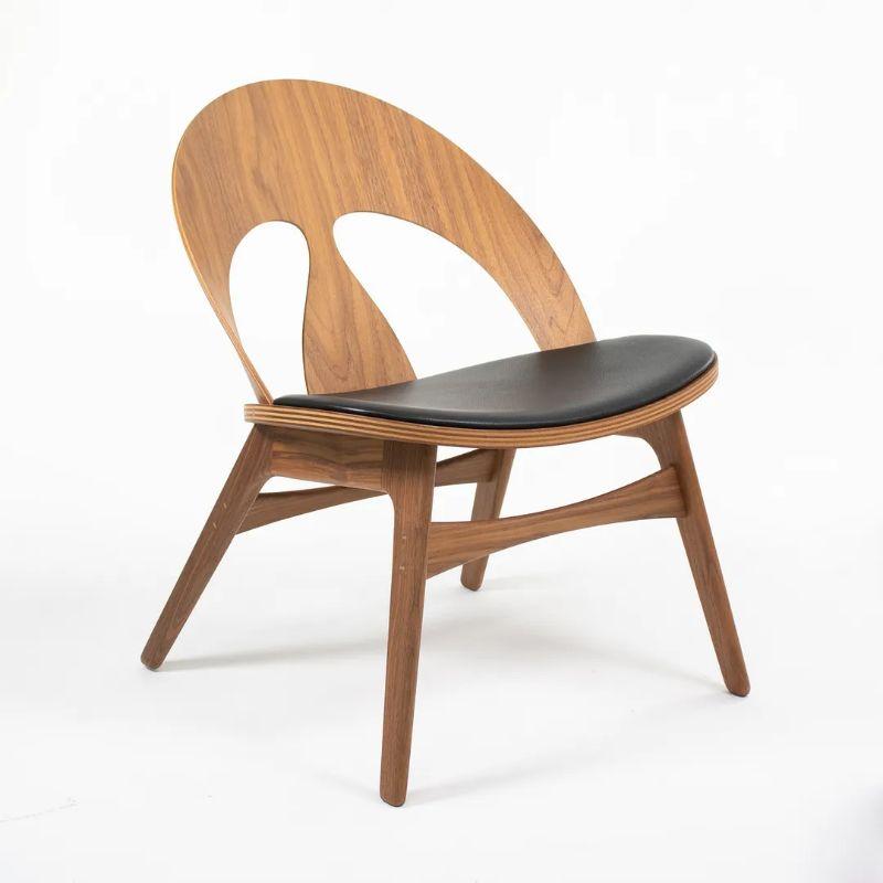 This is a BM0949P Contour lounge chair with a solid oiled walnut frame and black Loke 7150 leather seat. The chair was designed by Borge Mogensen and produced by Carl Hansen & Son in Denmark. It was made circa 2021 and is guaranteed as