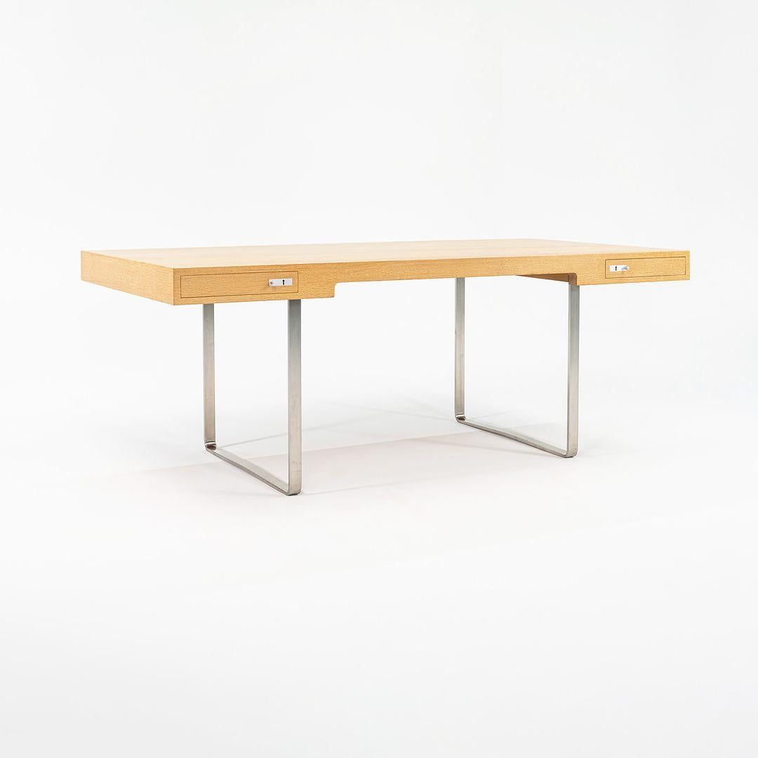 Il s'agit d'un bureau CH110 composé d'un plateau en chêne et d'une base en acier inoxydable. Le bureau, conçu par Hans Wegner et produit par Carl Hansen & Son au Danemark, date d'environ 2021 et est garanti authentique. L'état est excellent et