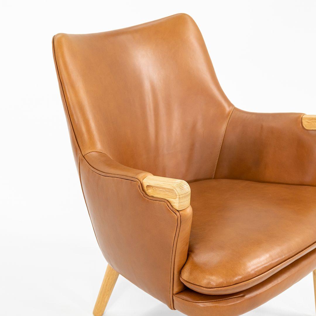 Dieser CH71 Lounge Chair wurde im Jahr 2021 hergestellt. Er wurde 2023 meisterhaft mit vollnarbigem italienischem hellbraunem/cognacfarbenem Leder neu gepolstert und der Rahmen scheint aus lackierter Eiche zu sein. Der Stuhl wurde von Hans Wegner