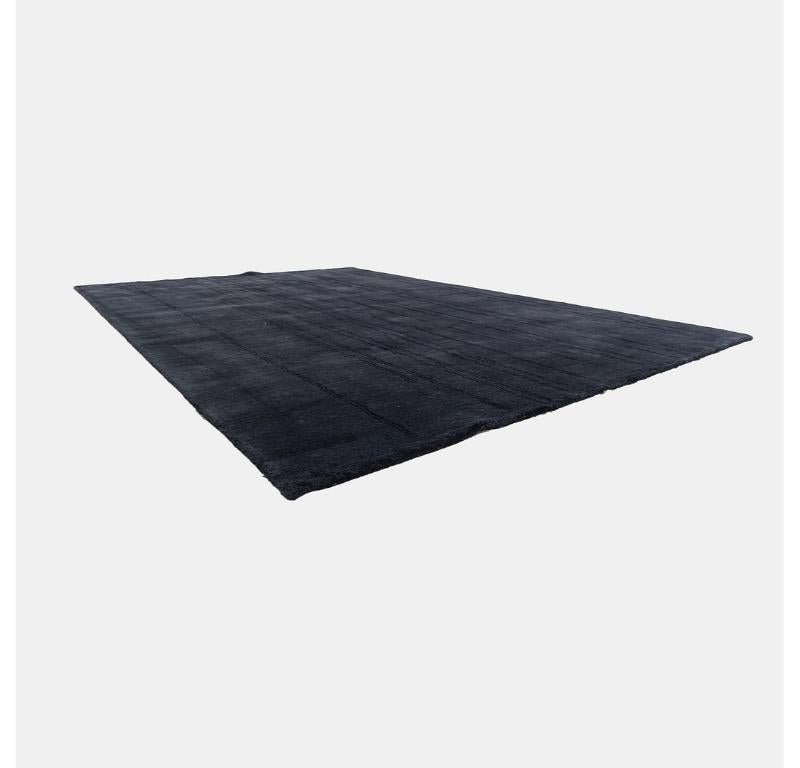 This is a NUP004 Woodlines area rug made with hand knotted woolen yarn in black with black lines. The rug was designed by Naja Utzom Popov and produced by Carl Hansen in Denmark. It dates to circa 2021 and is guaranteed as authentic. Condition is