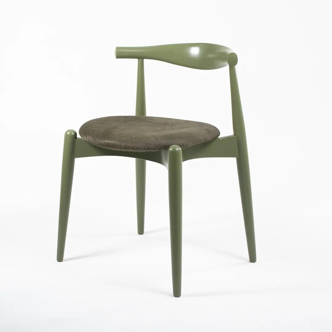 This is a CH20 Elbow Dining Chair made with a solid beech frame, painted green, with a green horsehair seat seat (the material was COL or Customers Own Leather). The chair, designed by Hans Wegner and produced by Carl Hansen & Son in Denmark, dates