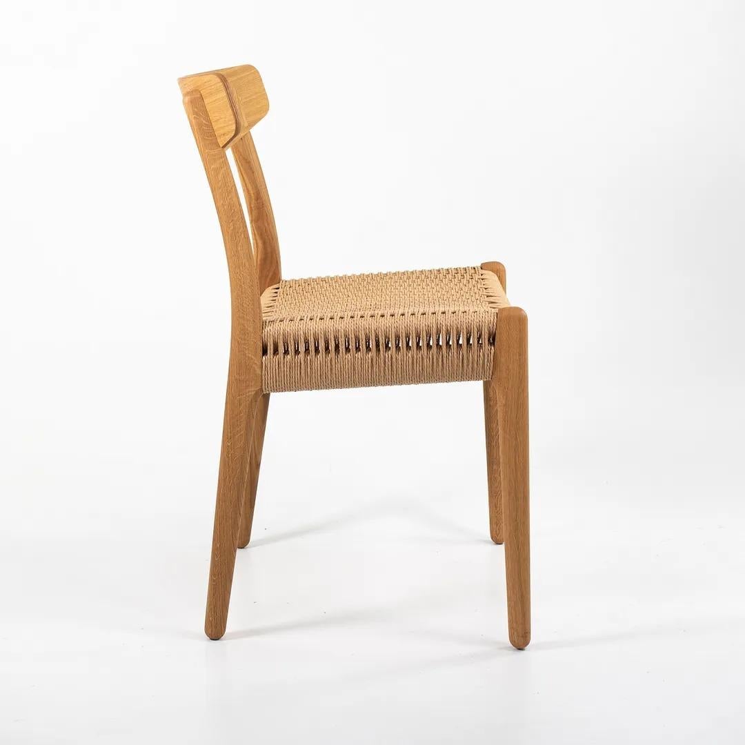 Dies ist ein CH23 Esszimmerstuhl, entworfen von Hans Wegner und hergestellt von Carl Hansen & Son in Dänemark. Der Stuhl besteht aus einem massiven, geölten Eichenholzrahmen mit einer Sitzfläche aus Naturpapierkordel. Der Stuhl stammt aus der Zeit