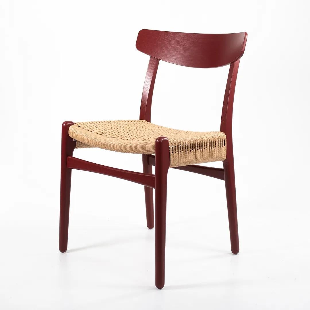 Listed for sale is a CH23 Dining Chair designed by Hans Wegner and produced by Carl Hansen & Son in Denmark. The chair is made with a solid oak frame, painted red (we believe. it to be Falu red, though do not guarantee it), with a natural paper cord