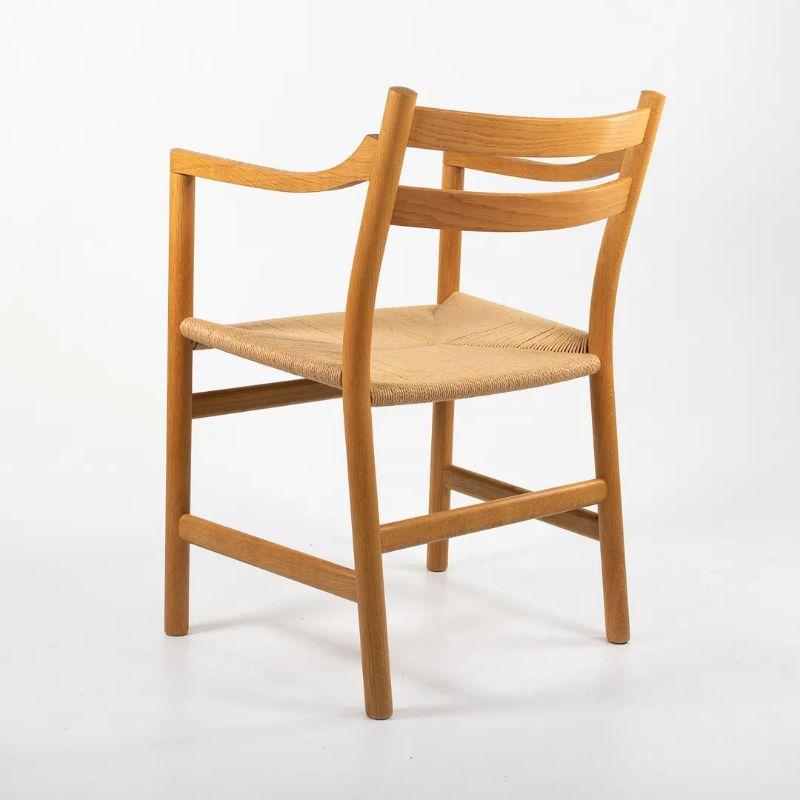 Questa è una sedia da pranzo CH46 disegnata da Hansen e prodotta da Carl Hansen & Son in Danimarca. La sedia è realizzata con una struttura in rovere massiccio, oliato, con una seduta in corda di carta naturale. Questa sedia risale al 2021 circa ed