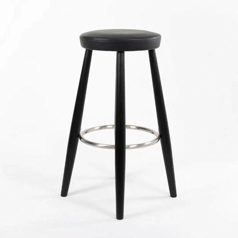 Listed for sale are two (sold separately) CH56 Bar Stools, designed by Hans Wegner and produced by Carl Hansen & Son in Denmark. The stools are made with an ebonized oak frame and black leather seat (seemingly Like 7150). These stools date to circa