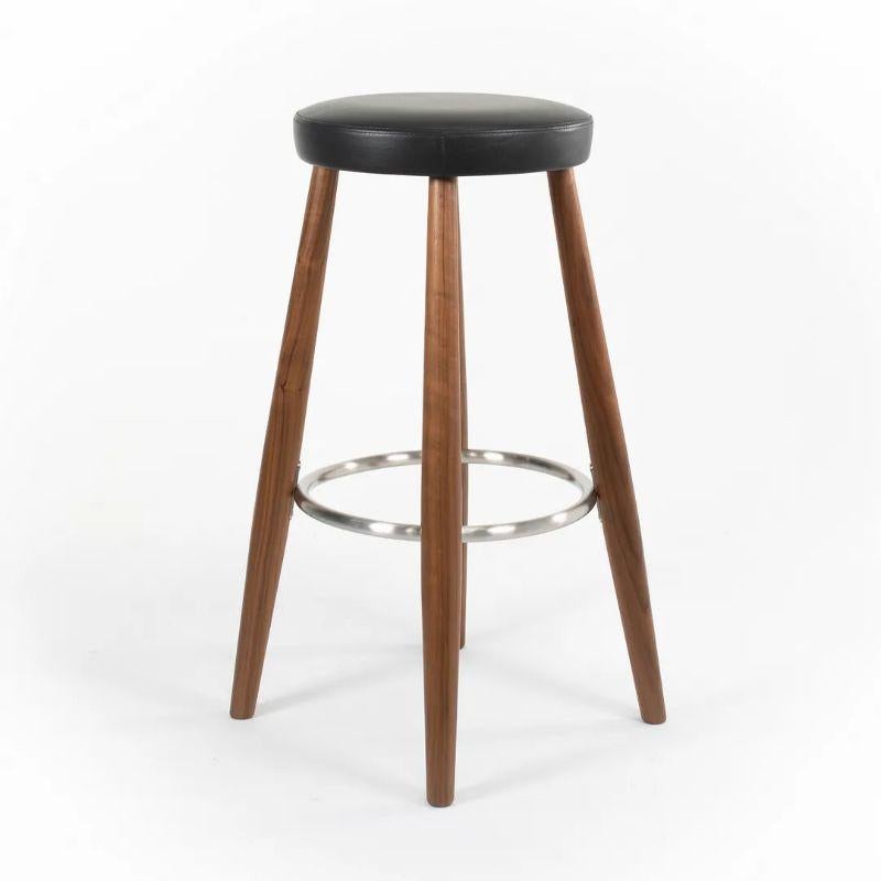 Listed for sale is a CH56 Bar Stool designed by Hans Wegner, produced by Carl Hansen & Son in Denmark. The stool is made with a solid walnut frame and a black Thor leather seat. This stool dates to circa 2021 and is guaranteed as