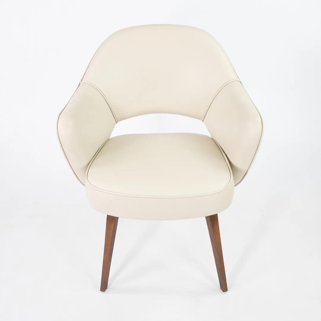 This is an Eero Saarinen for Knoll executive armchair in off-white leather with light walnut wood legs. The chair was produced in 2021, acquired directly from a Knoll employee. It has never been used in a home or office setting. 

The color looks
