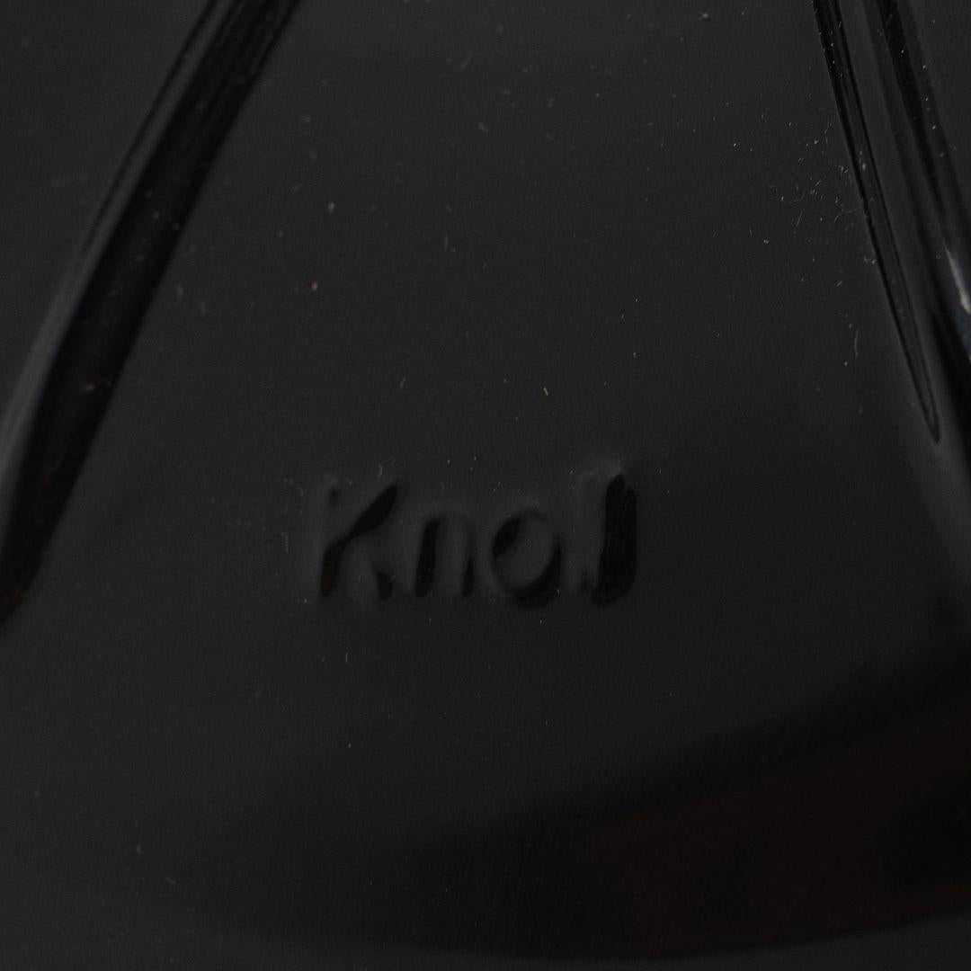 This is an oval Tulip Pedestal Side Table, originally designed in 1956 by Eero Saarinen for Knoll. This particular piece was produced in Italy in 2021. The base is formed of molded cast-aluminum which has a glossy black enameled finish. It features