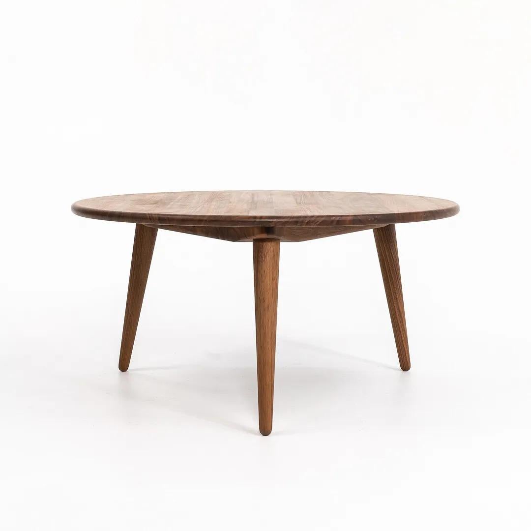 Cette table basse CH008 est composée d'un plateau et de pieds en noyer massif huilé. La table, conçue par Hans Wegner et produite par Carl Hansen & Son au Danemark, date d'environ 2021 et est garantie authentique. L'état est excellent et ne présente
