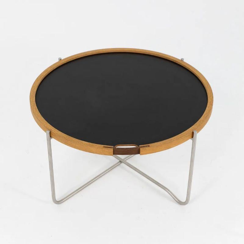 This is a listing for three (sold individually) CH417 Tray Tables, made with a black/white reversible wood and laminate top and stainless steel legs. The tables, designed by Hans Wegner and produced by Carl Hansen & Son in Denmark, date to circa