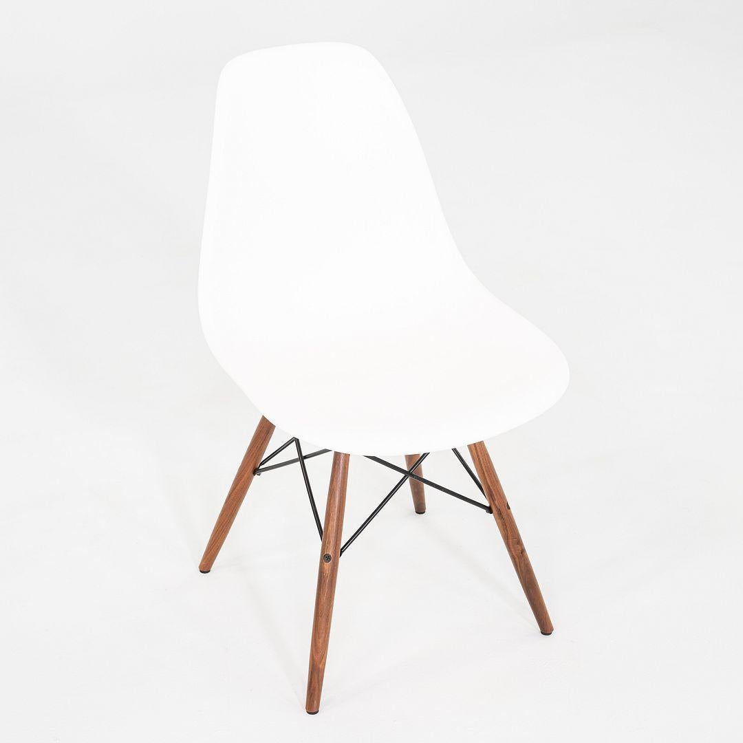 Il s'agit d'une chaise DSW, conçue à l'origine par Charles et Ray Eames pour Herman Miller en 1950. Ces exemplaires ont été produits aux États-Unis en 2021. Les chaises sont dotées d'une coque classique en plastique moulé blanc, d'une base à