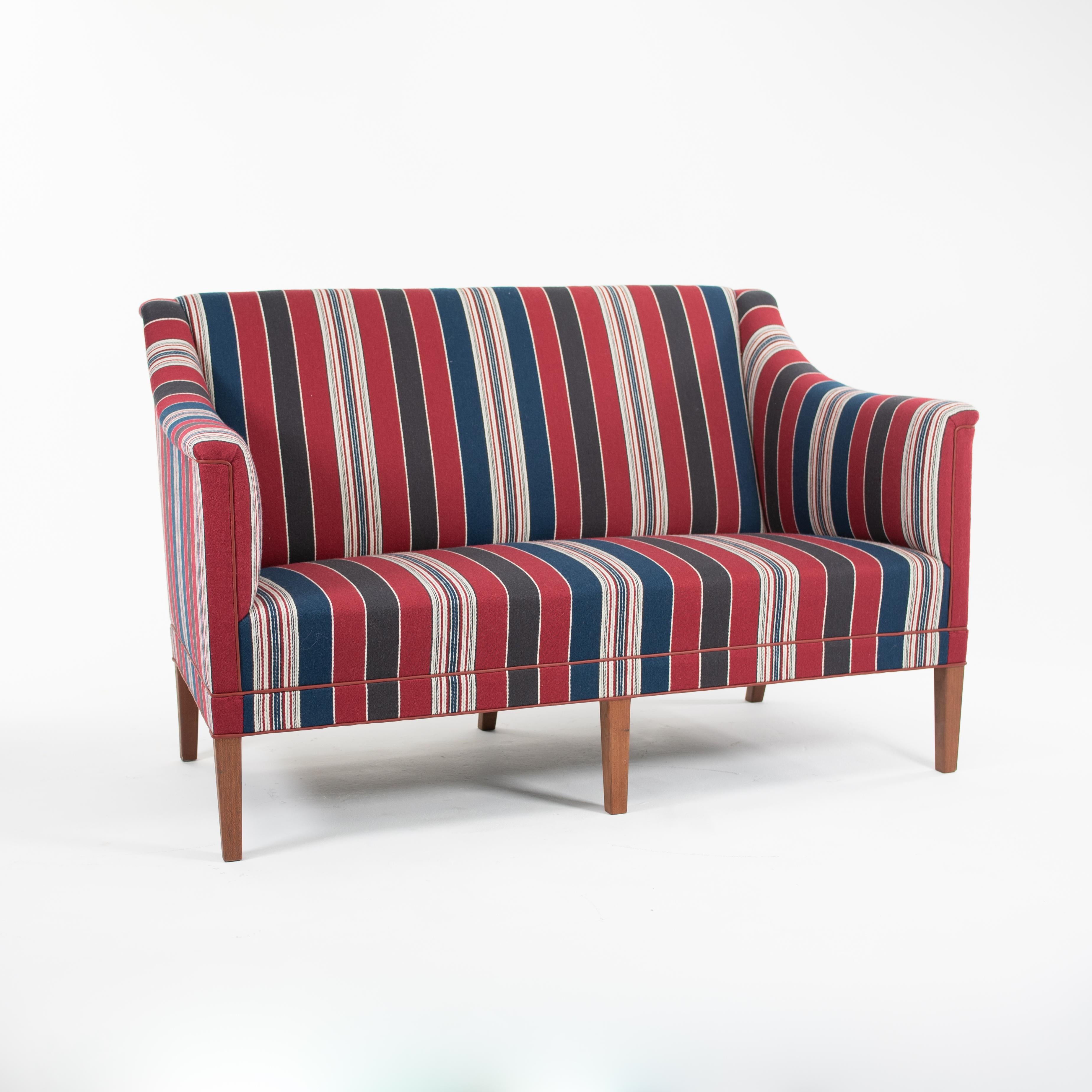 In vendita c'è un divano a due posti KK6092 con struttura in mogano massiccio laccato e rivestimento in tessuto a righe. La poltrona, disegnata da Kaare Klint e prodotta da Carl Hansen & Son in Danimarca, è stata prodotta intorno al 2021. È