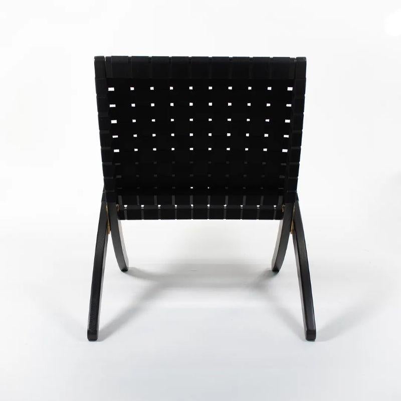 This is an MG501 Cuba Lounge Chair made with a black oak frame and a black cotton webbing seat/back. The folding chair, designed by Morten Gottler and produced by Carl Hansen & Son in Denmark, dates to circa 2021 and is guaranteed as authentic.
