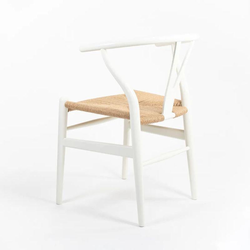 Il s'agit d'un ensemble de sept chaises de salle à manger Wishbone, conçues par Hans Wegner et produites par Carl Hansen & Son au Danemark. Les chaises sont fabriquées avec une structure en hêtre massif, peinte en blanc avec une assise en corde de