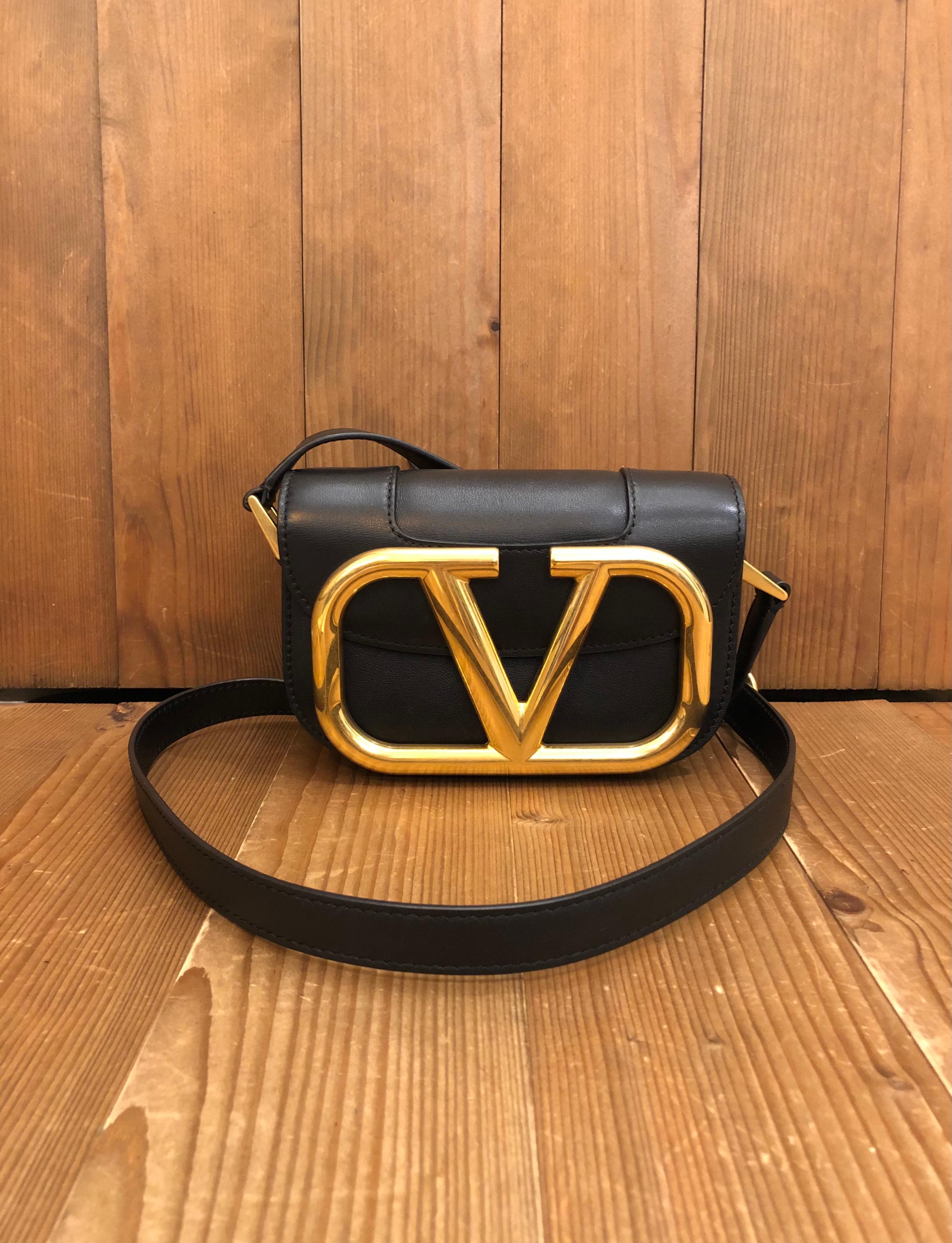 Valentino Garavani Supervee crossbody bag in the finest calfskin leather and gold toned hardware featuring a top flap magnetic closure and adjustable shoulder/crossbody strap. Super V-logo stands out from the crowd. It is compact in size.
Made in