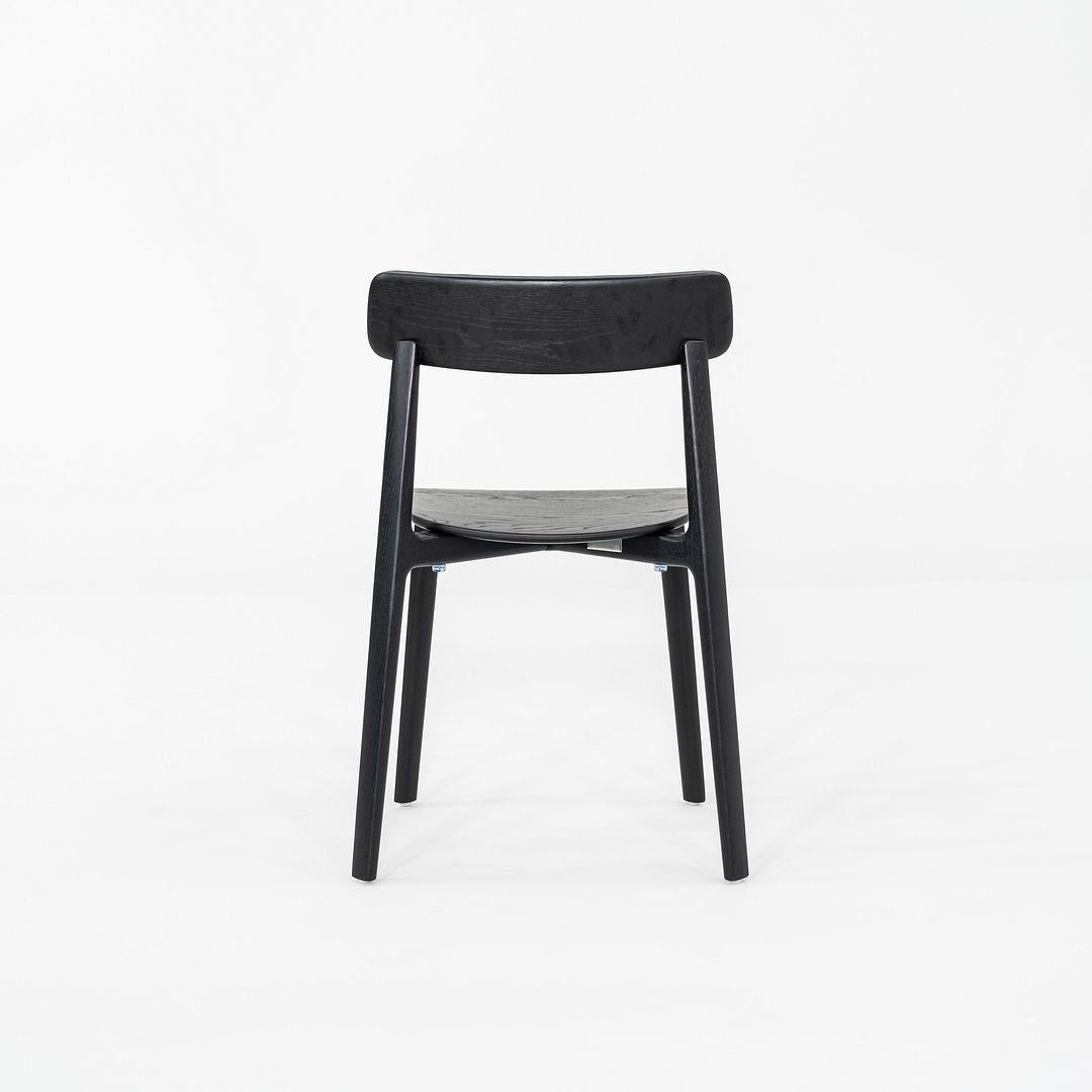 This is an Aatos Stacking Chair, originally designed by Antti Kotilainen in 2022. This particular example was produced by CondeHouse in Japan in 2022. The chair is comprised of a black Japanese oak frame and the back is upholstered in black leather.