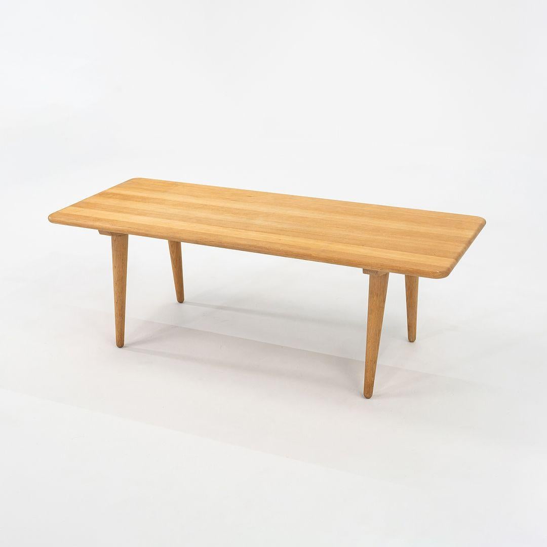 This is a CH011 Coffee Table Table made of solid oak with a soaped finish. The CH011, designed by Hans Wegner and produced by Carl Hansen in Denmark, dates to circa 2022 and is guaranteed as authentic. 
 
 The CH011 Table measures 51.1 inches long,