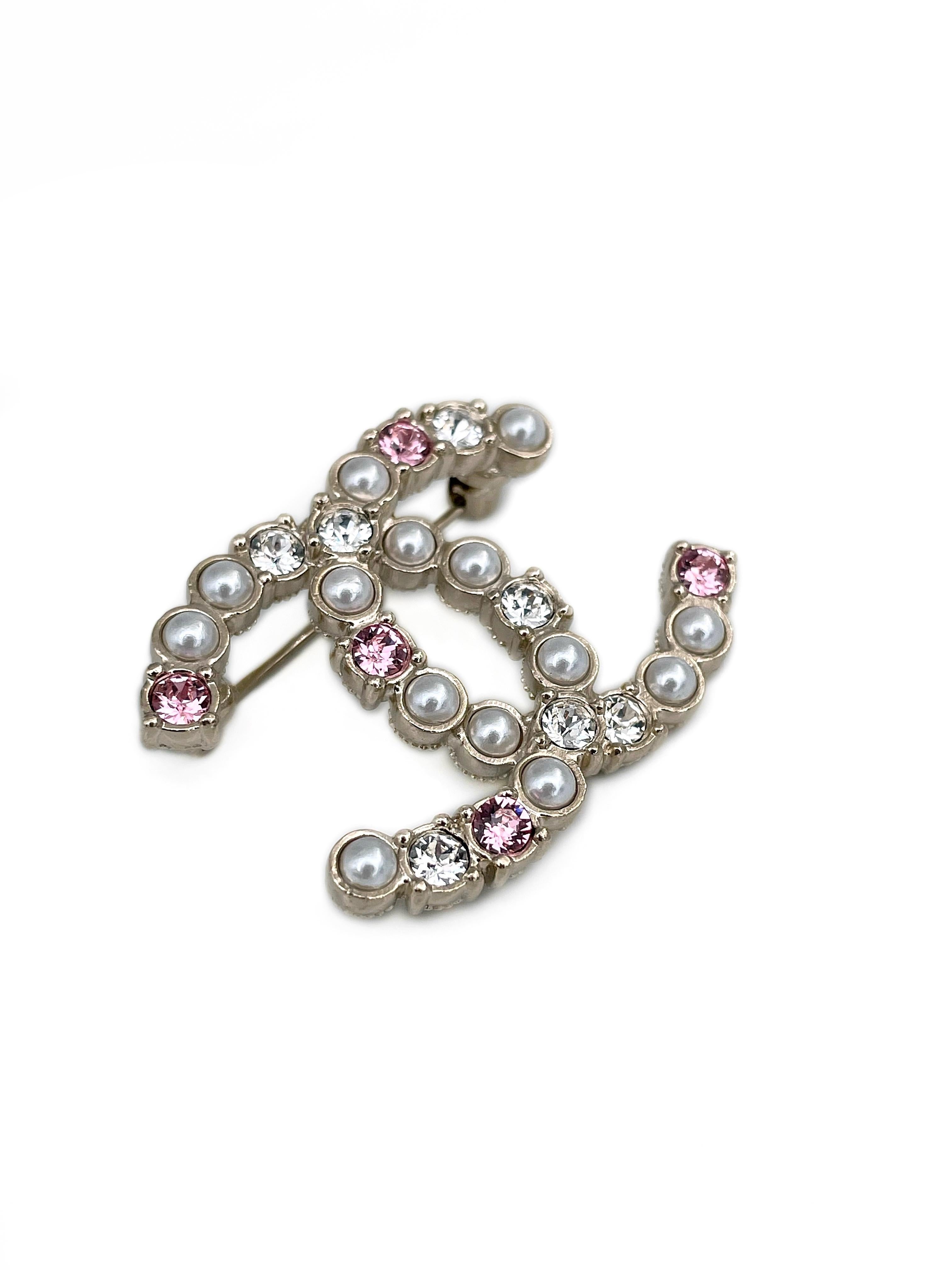 Se trata de un broche con el logotipo CC diseñado por Chanel para la colección 2022. Está adornada con cristales brillantes rosas y transparentes. La pieza también lleva perlas de imitación. 

Firmado: ©Chanel® A22C. Fabricado en Francia

Tamaño: