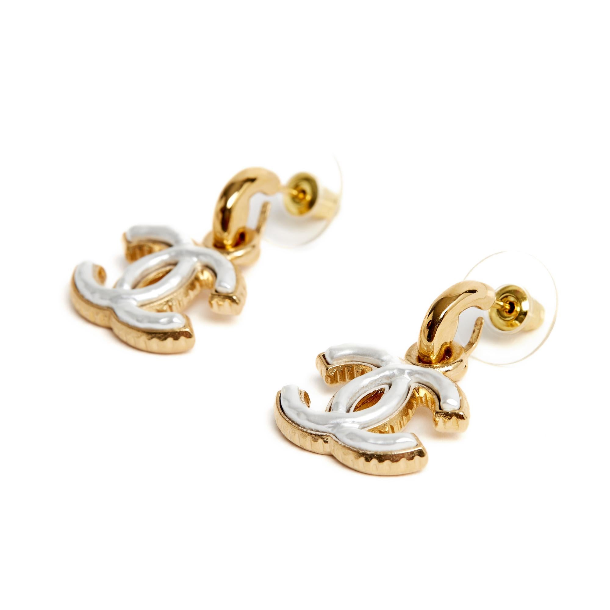 Chanel earrings composed of a very small hoop and a pendant with the motif of a Chanel CC logo in gilt metal inlaid with white mother-of-pearl (fantasy). Total height of the earring 2.65 cm, dimensions of the CC 2 x 1.5cm. The earrings are from a