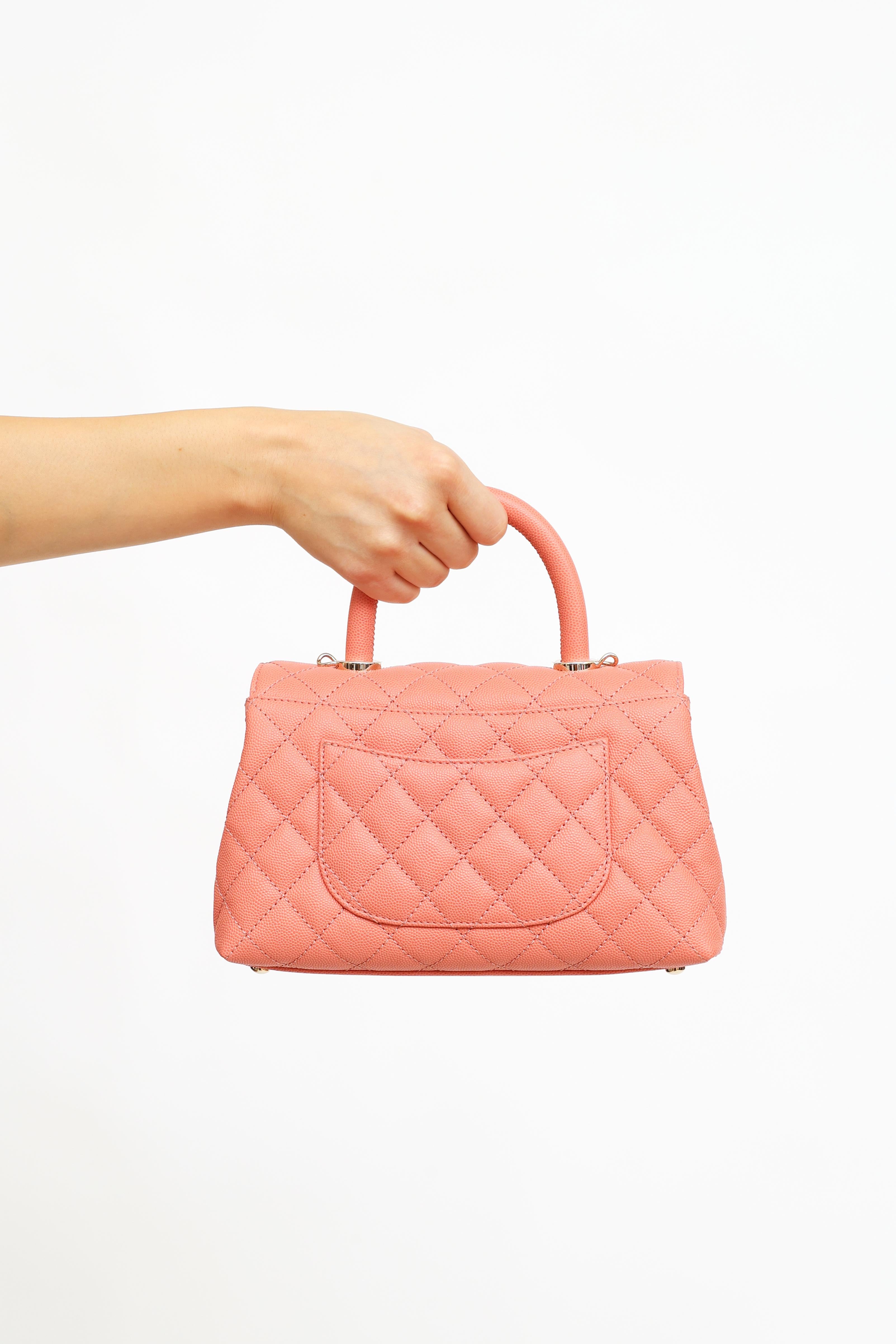 Pre-owned Chanel Caviar Coco handle bag in pink featuring detachable woven shoulder strap gold-tone hardware. Mona Lisa pocket at back with front fold over flap and gold-tone CC logo twist lock. Signature Caviar quilted leather. Interior features
