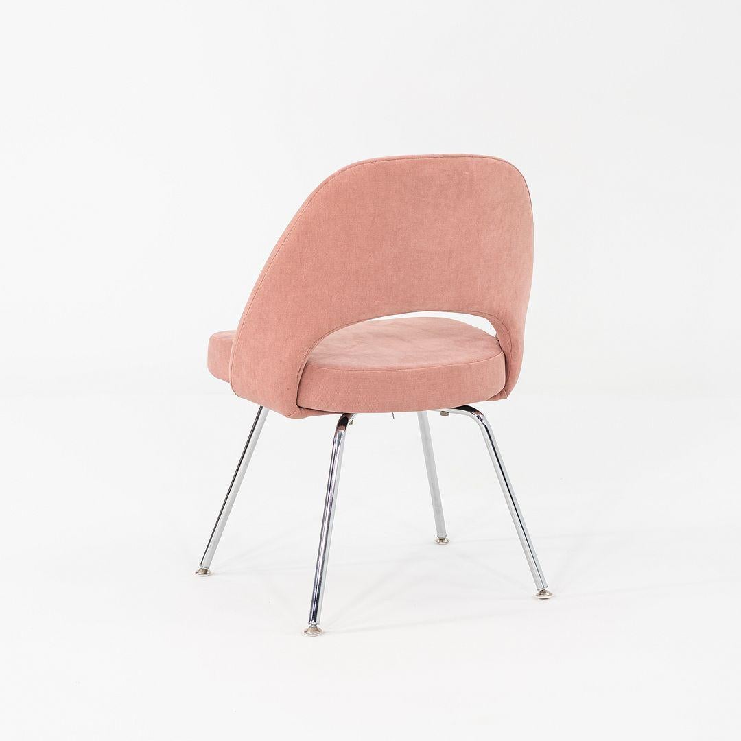 This is a Saarinen Executive Side Chair, originally designed by Eero Saarinen in 1957. These particular examples were produced by Knoll in the USA in 2022. The chairs feature upholstered seats in pink fabric, and the legs are formed of chromed
