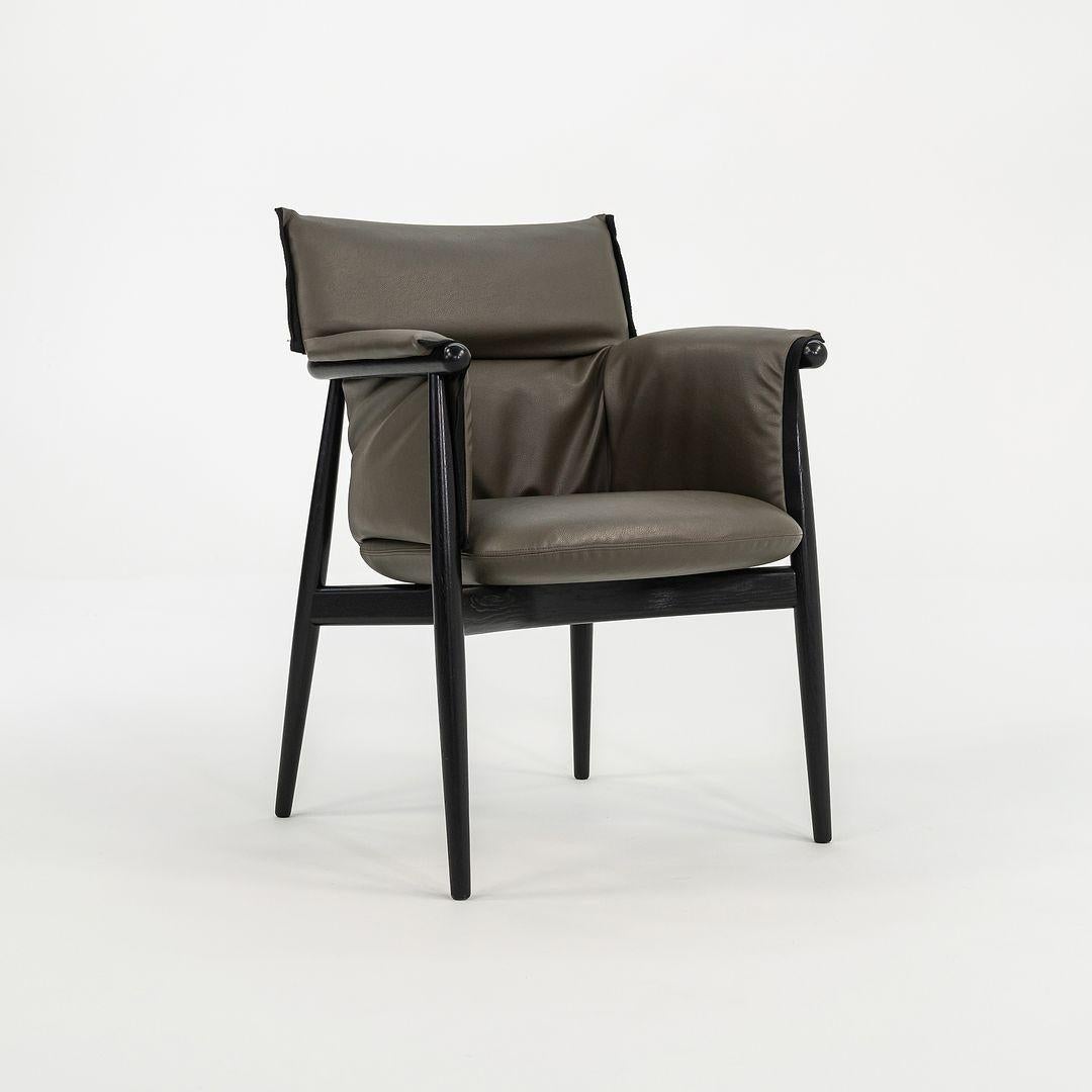 Il s'agit d'un fauteuil Embrace, modèle E005, fabriqué à partir d'une structure en chêne massif avec une finition noire et une assise en cuir gris. La chaise, conçue par EOOS et produite par Carl Hansen & Son au Danemark, date d'environ 2022 et est