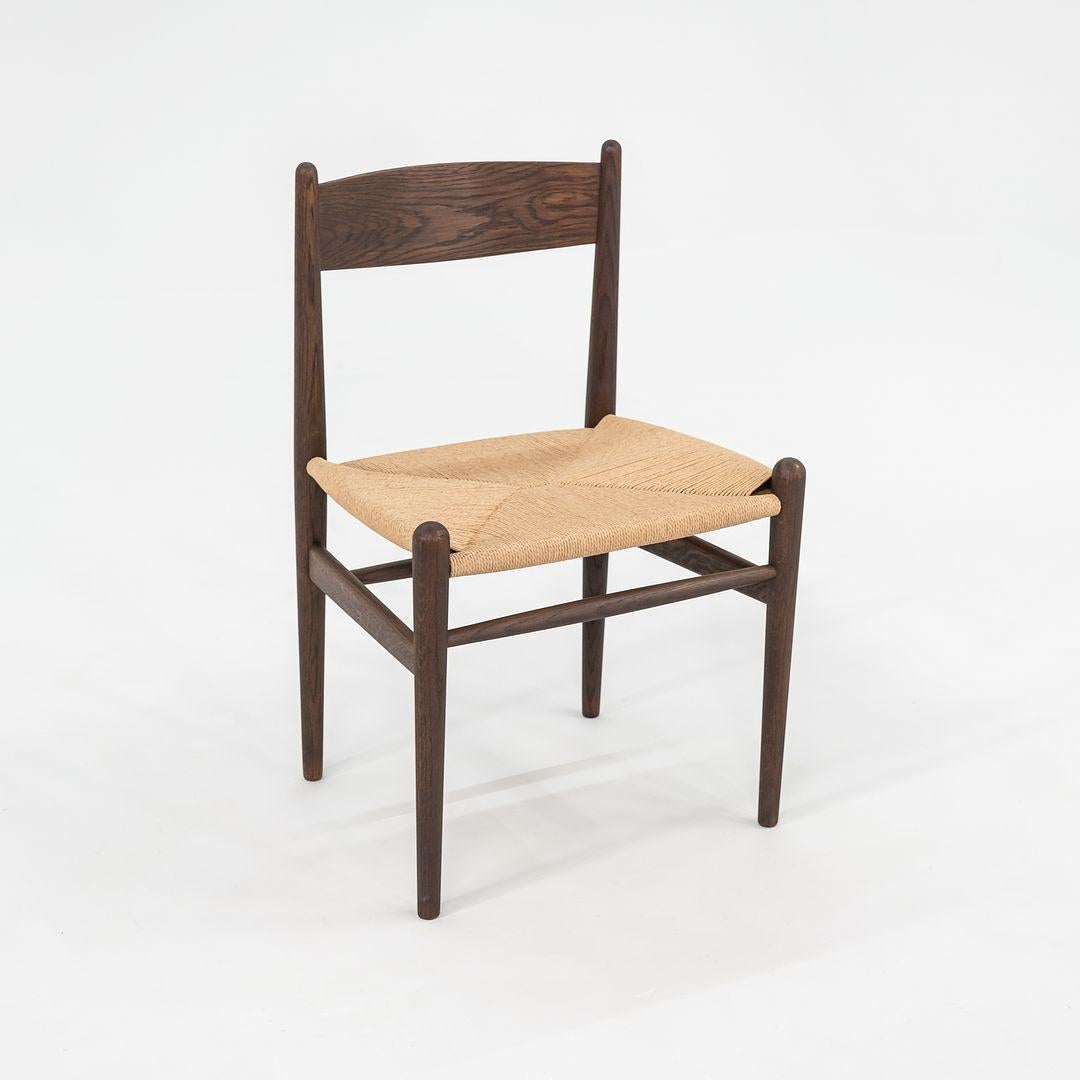 Il s'agit d'une chaise de salle à manger CH36 avec un cadre en chêne massif à l'huile fumée et une assise en corde de papier naturel. La chaise, conçue par Hans Wegner et produite par Carl Hansen & Son au Danemark, a été produite vers 2022 et est
