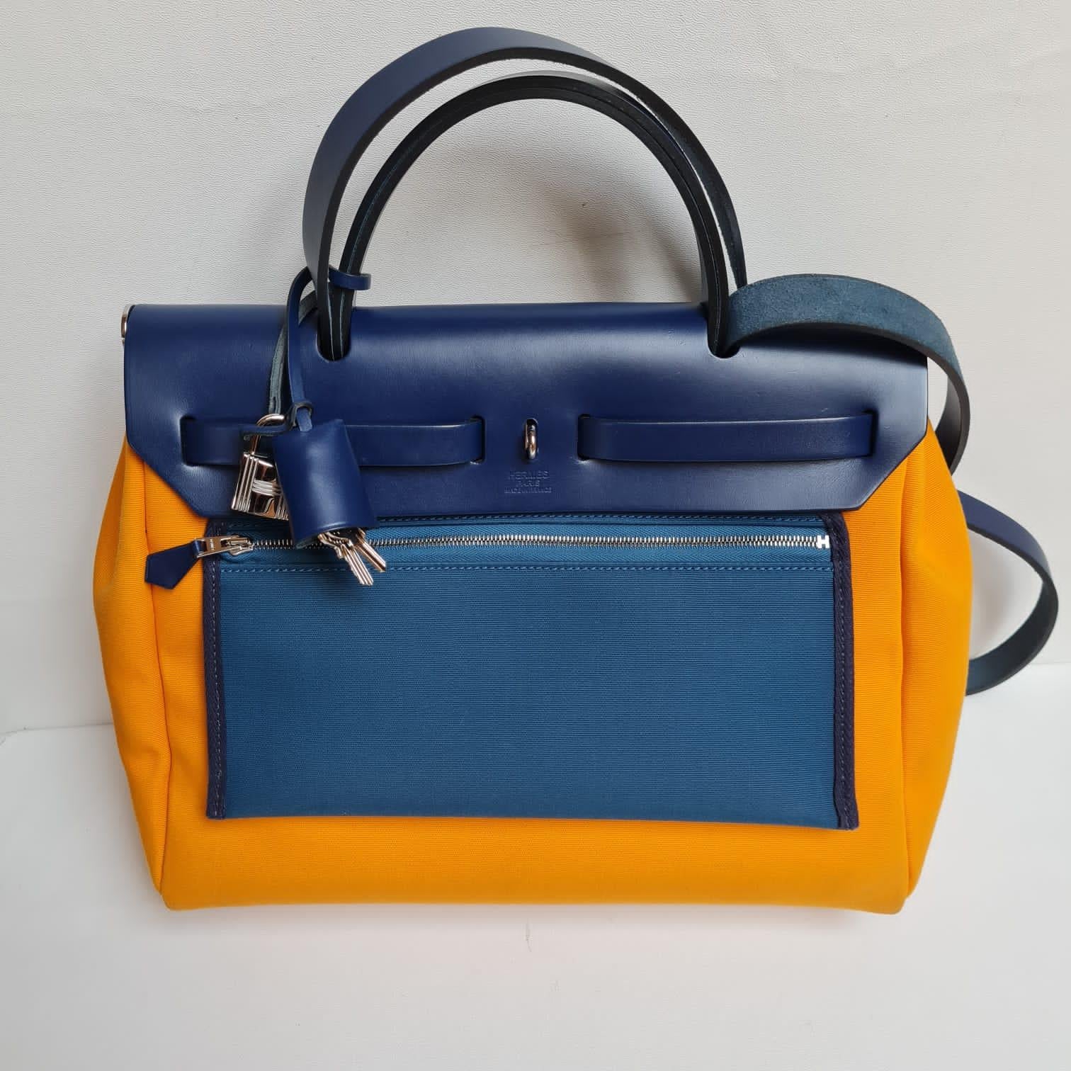 Beautiful new herbag 31 in navy and orange. Overall still in excellent condition with minor scratches on the flap top. Comes with its inner pouch and dust bag. Will give entrupy certificate of the item.