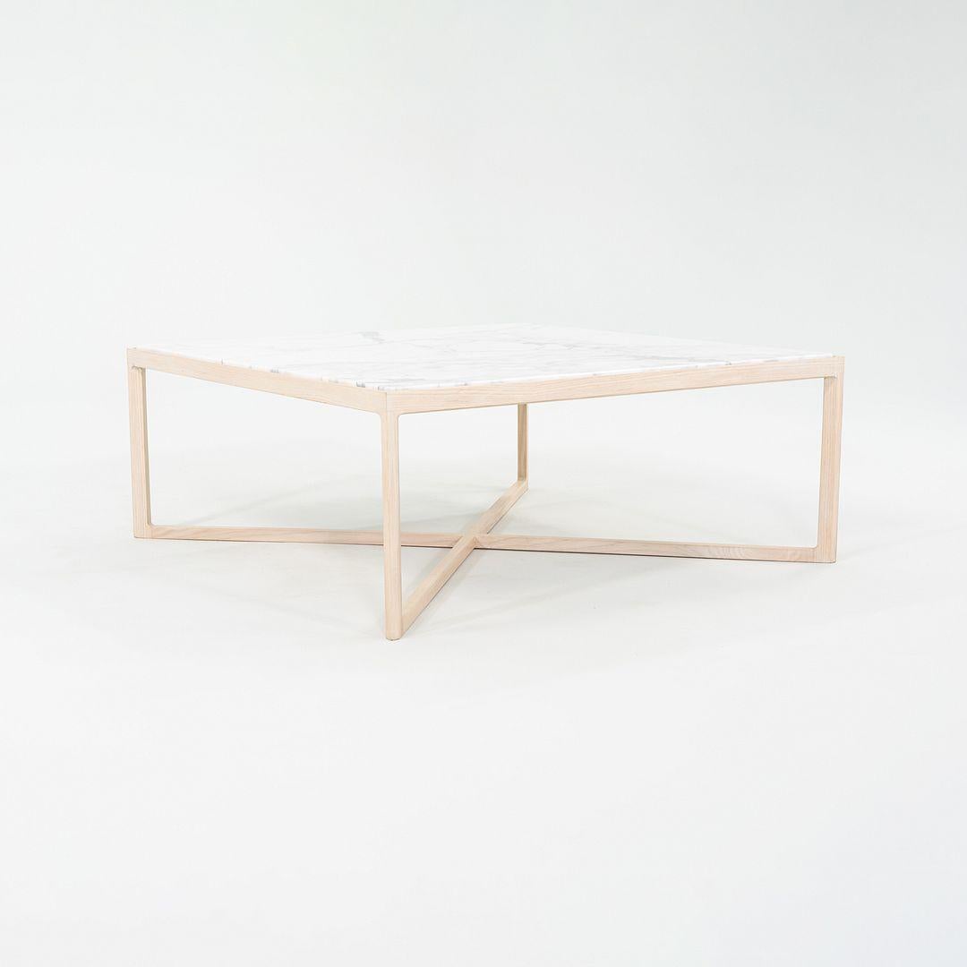 This is a Krusin Coffee Table, designed by Marc Krusin for Knoll in 2011. This example dates to 2022. The top is made of satin-coated Italian Arabescato marble that is quarried in the Carrara region, and the frame is made of natural oak. The base