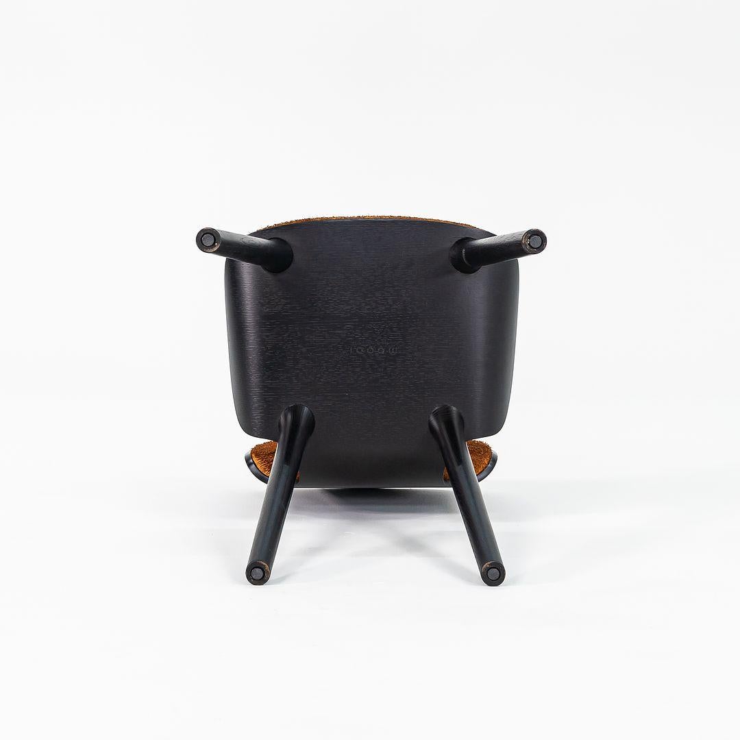 Listed for sale is a Nut Dining Chair made with a black oak frame and cognac / orange colored fabric. The chair was designed by Marcel Wanders and produced by Moooi¬†in the Netherlands. It dates to circa 2022 and is guaranteed as