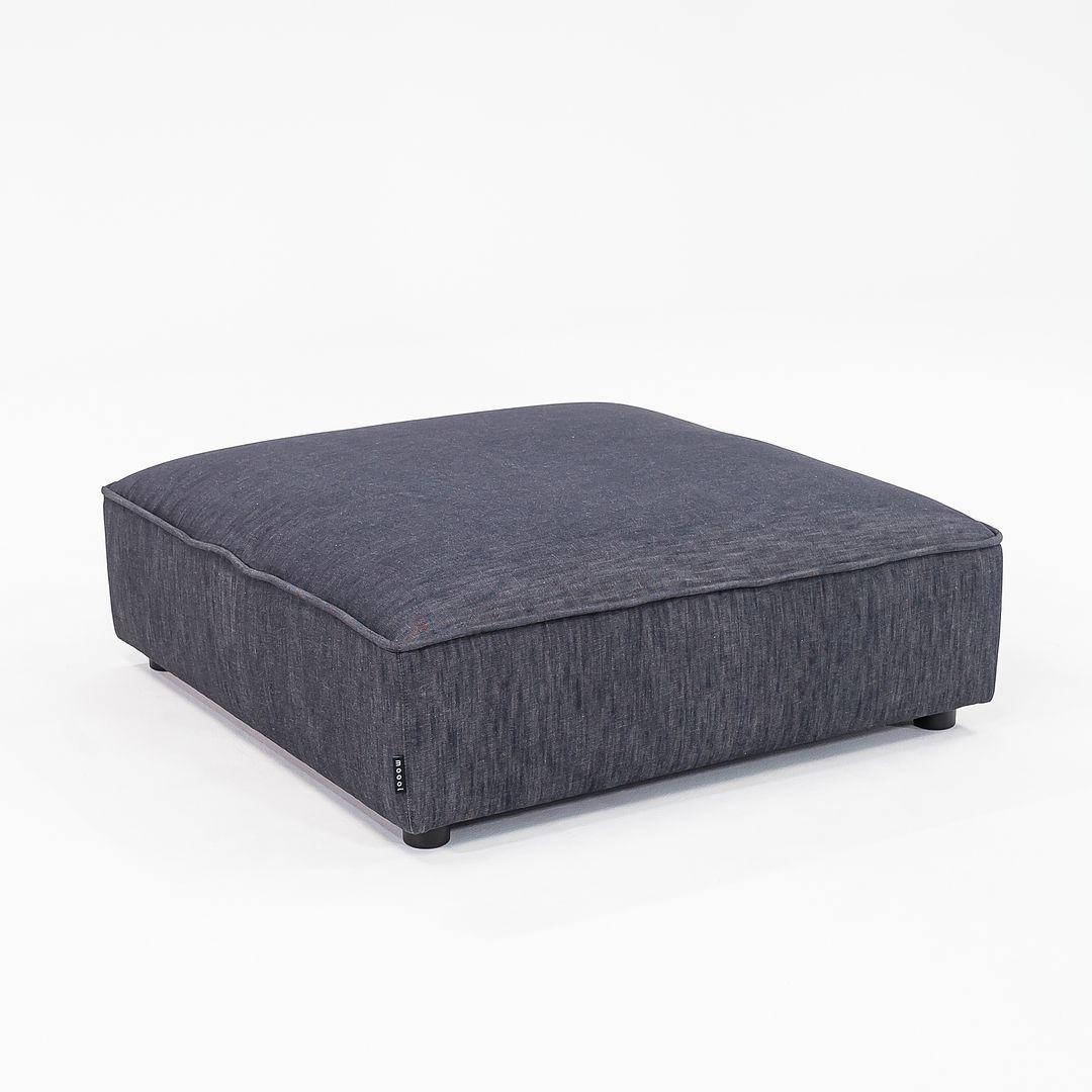 Se vende un Reposapiés Sofa So Good fabricado con estructura de acero, tela vaquera de algodón negro (medianoche) y patas de madera. El reposapiés fue diseñado por Marcel Wanders y producido por Moooi¬†en Holanda. Data de hacia 2022 y está