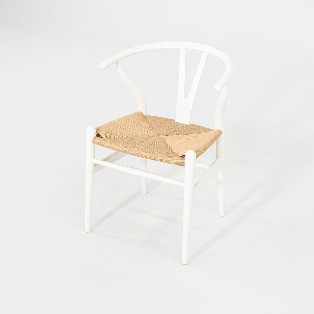 Questa è una sedia da pranzo CH24 Wishbone, disegnata originariamente da Hans J. Wegner nel 1949. Questo particolare esemplare è stato prodotto da Carl Hansen in Danimarca nel 2023. La sedia è realizzata con una solida struttura da spiaggia bianca e