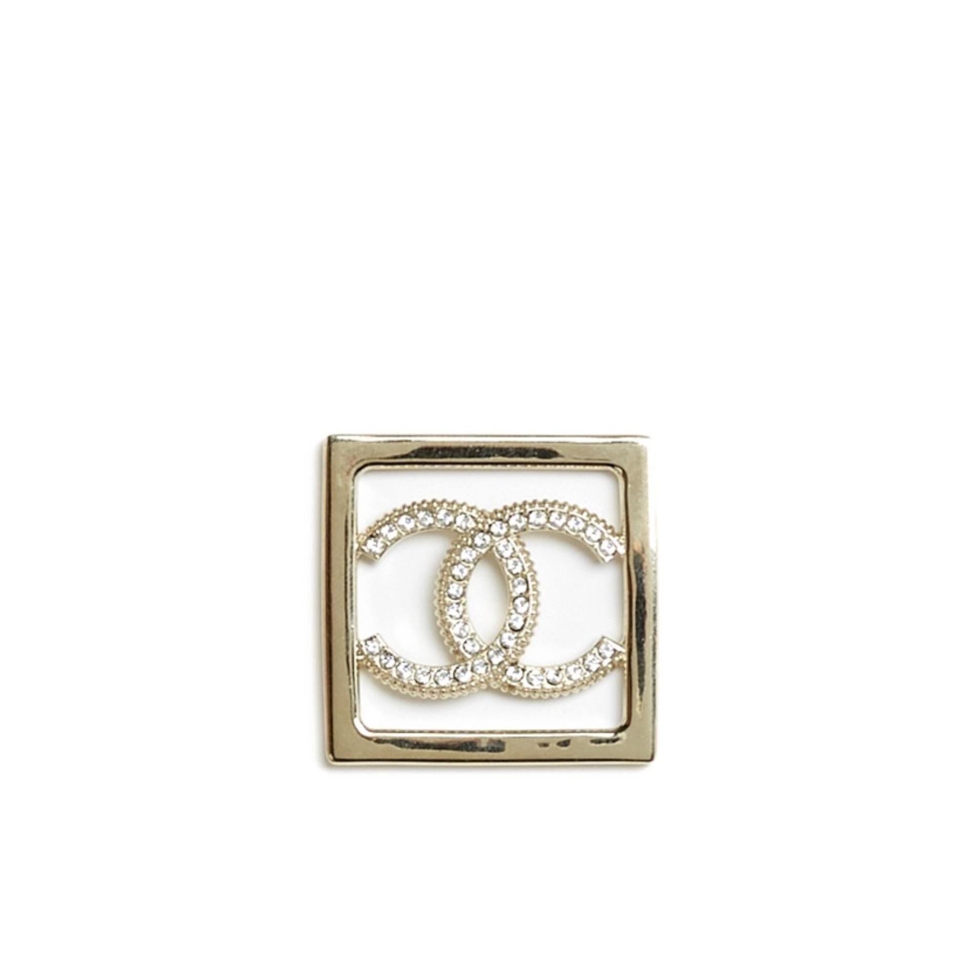 Chanel stud earrings in lightly gold-plated metal, with the motif of a square surrounding the CC symbol paved with small white rhinestones. Width 4.05 cm x height 4.05 cm. The earrings are delivered without invoice or original packaging but they are