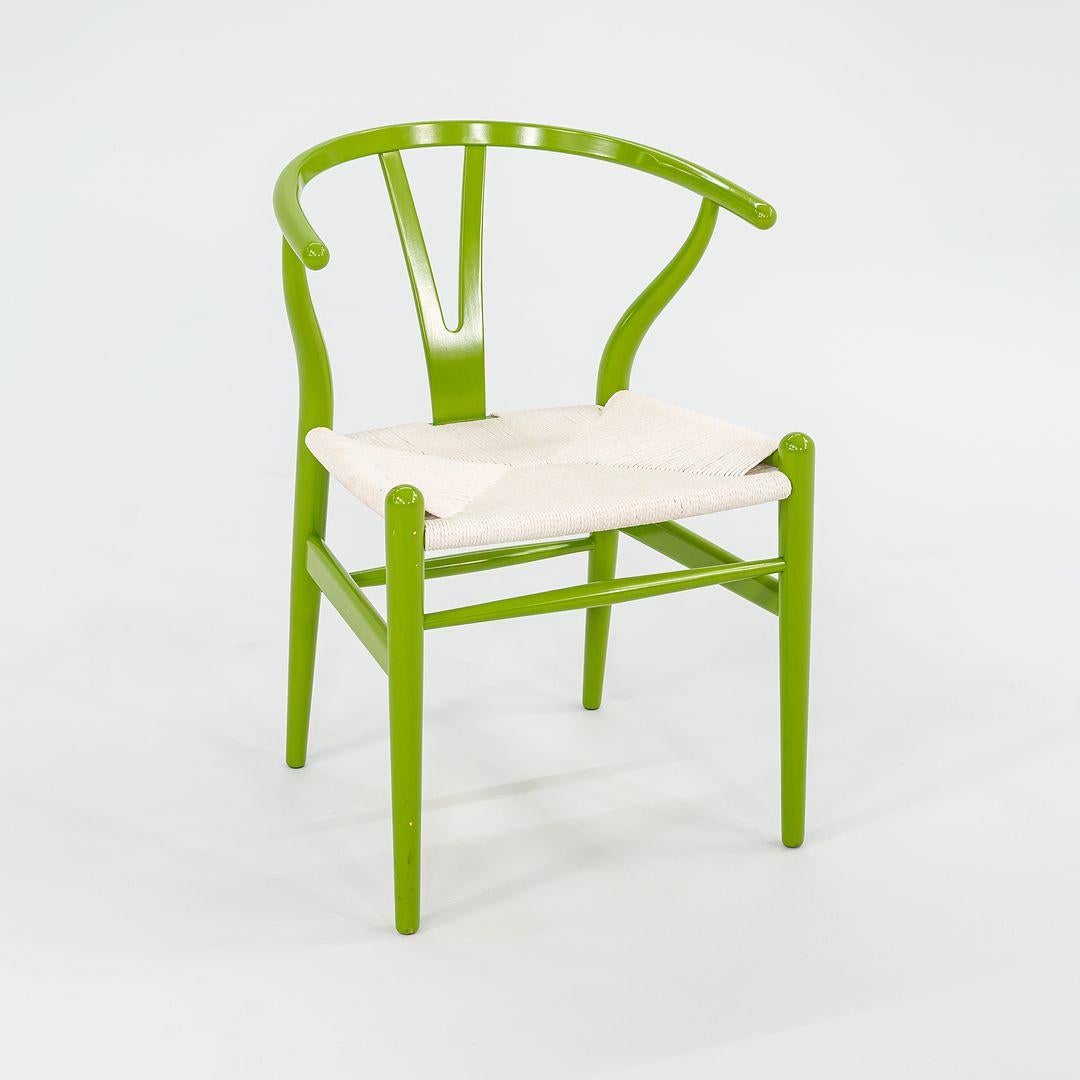 Questa è una sedia da pranzo Wishbone CH24 con struttura in faggio massiccio verniciata in verde primavera e seduta in corda di carta bianca. Questa sedia è stata disegnata da Hansen e prodotta da Carl Hansen in Danimarca. Risale al 2023 circa ed è