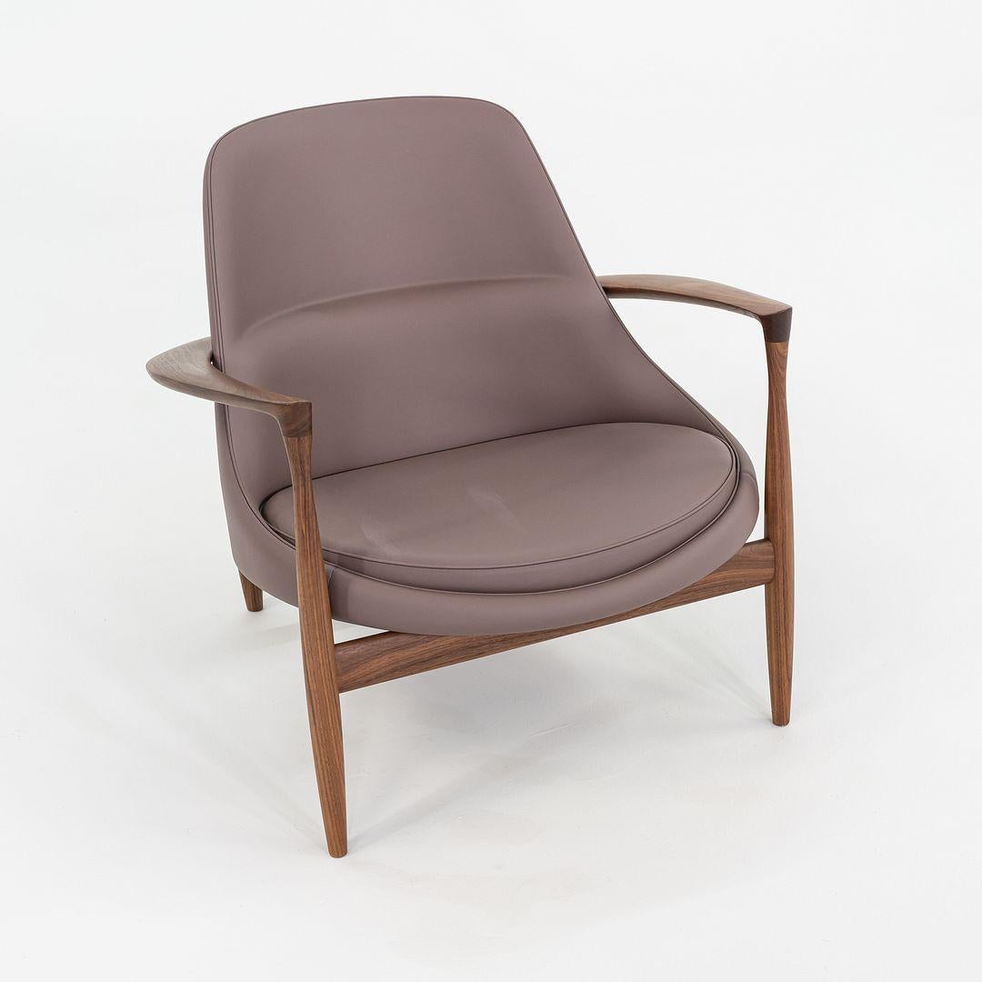 Dies ist ein Elizabeth Lounge Chair und Ottoman, ursprünglich entworfen von Ib Kofod-Larsen im Jahr 1956. Dieses besondere Exemplar wurde von Audo Copenhagen C. 2023 hergestellt. Das Design des Stuhls besteht aus einem Gestell aus Nussbaumholz und
