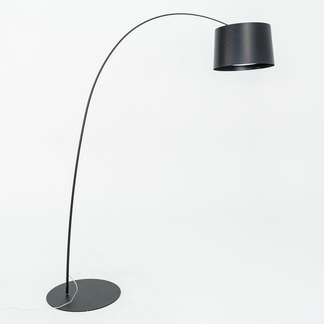 Il s'agit d'un lampadaire Twiggy, conçu à l'origine par Marc Sadler pour Foscarini en 2006. Cet exemple particulier a été produit en 2023. La lampe est composée d'un socle en métal peint par poudrage, d'une tige en composite et d'un disque diffuseur