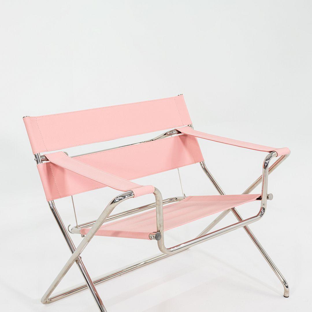 Se trata de una tumbona plegable D4, diseñada originalmente por Marcel Breuer en 1926. Este ejemplar en concreto fue fabricado por Tecta en Alemania C. 2023. La silla se compone de un armazón tubular de acero cromado con un asiento de tela rosa. 
 
