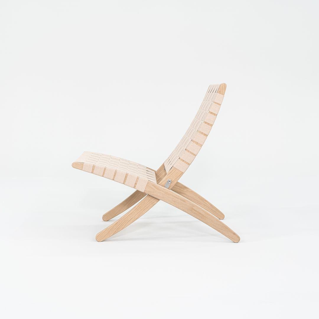 Esta es una Silla de Salón Cuba MG501 fabricada con una estructura de roble macizo con acabado jabonoso y cinchas de algodón natural. Esta silla fue diseñada por Morten Gottler y producida por Carl Hansen en Dinamarca. Data de hacia 2023 y está
