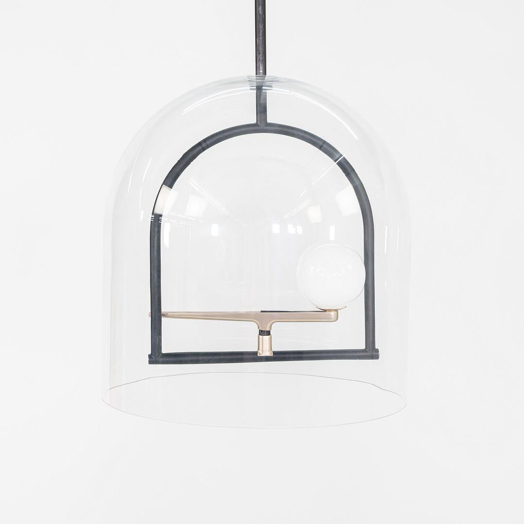 Questa è una lampada LED a sospensione Yanzi, originariamente progettata da Neri & Hu. Questo particolare esemplare è stato prodotto da Artemide in Italia C.C. 2023. La lampada è composta da ottone spazzolato, vetro soffiato e acciaio. Le specifiche