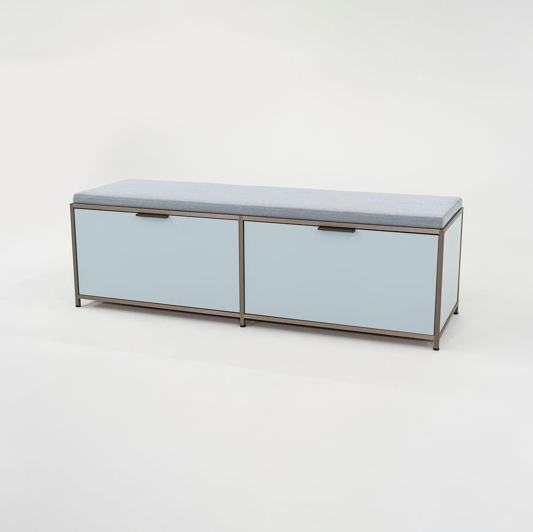 Nous proposons à la vente un meuble-lit DITA avec deux portes battantes. Le banc est composé de panneaux de bois laqués bleu clair et d'un cadre en aluminium anodisé avec un coussin en tissu de laine gris bleu. Le banc a été conçu par Pagnon et